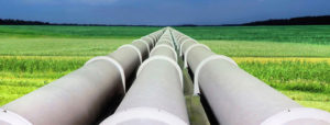 Concept image for energy procurement shows three large supply pipes, side by side, stretching to the horizon