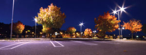 Night time view of a parking lot illuminated with LED street lamps and LED spotlights