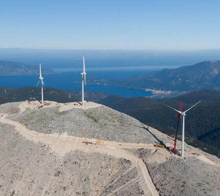 Daytime aerial view of wind turbines on a hilltop in Kefalonia, Greece